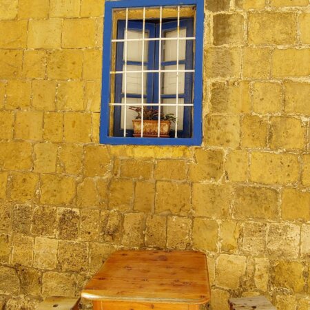 Cobalt window frame overlooking table and benches